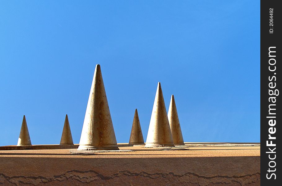 Spiked metal with rust and blue sky. Spiked metal with rust and blue sky