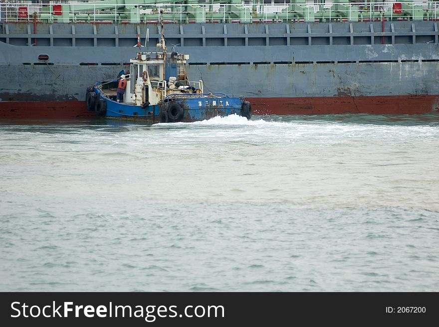 Tug boat moving a ship into place