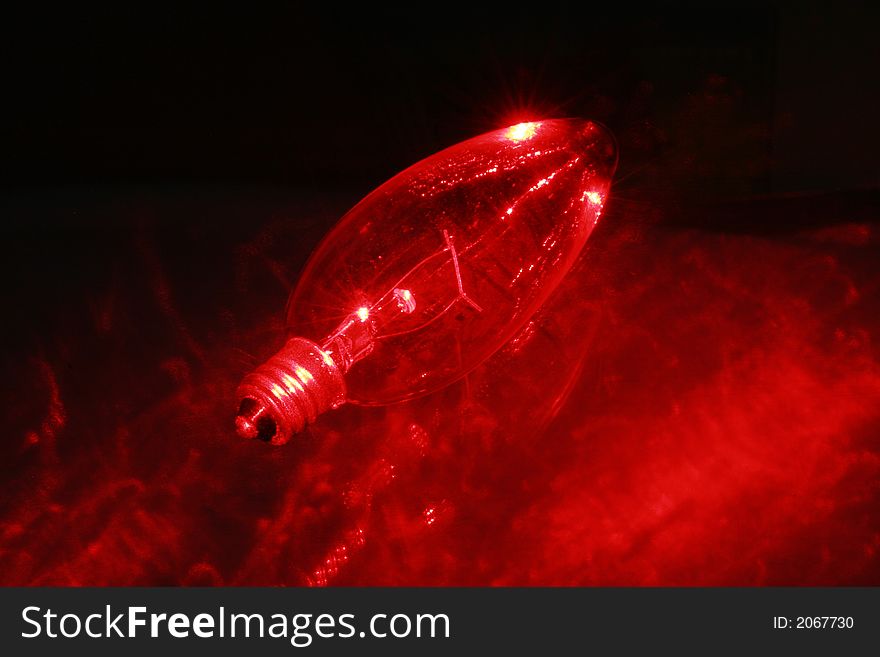 Red light bulb lit with laser light on a piece of glass. Red light bulb lit with laser light on a piece of glass