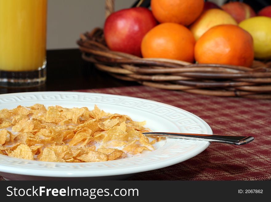 Cereal and milk, with fruit and juice in the background. Cereal and milk, with fruit and juice in the background.