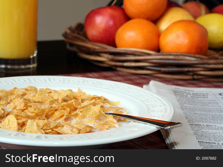 Cornflakes and milk, juice and fresh fruit, and a newspaper. Cornflakes and milk, juice and fresh fruit, and a newspaper.