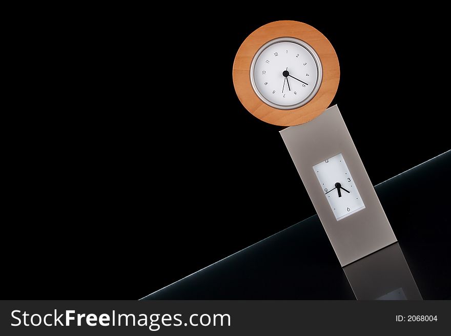 Two clocks stacked on each other against a black background.