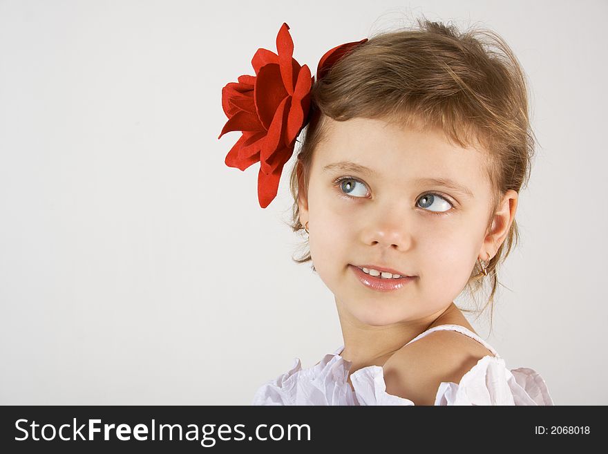 Little girl with red rouses in the hair