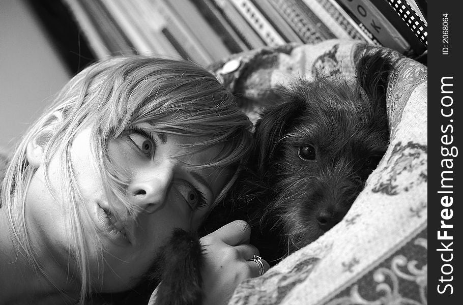 Girl and dog are lying on bed. Black-white photo. Girl and dog are lying on bed. Black-white photo.