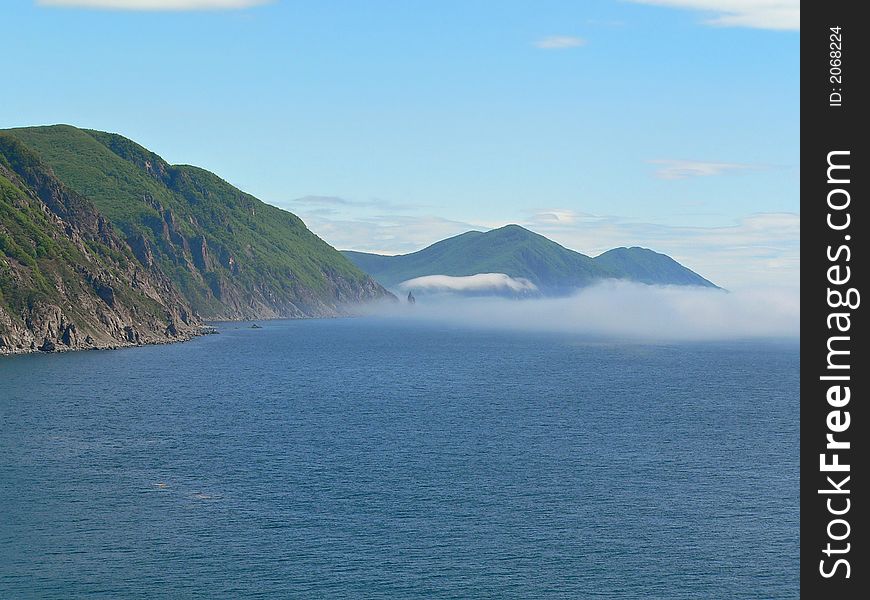 Seacoast of state nature reserve Lazovsky. Cliffs and rocks. The layers of fog are distantly. Russian Far East, Primorye. Seacoast of state nature reserve Lazovsky. Cliffs and rocks. The layers of fog are distantly. Russian Far East, Primorye.