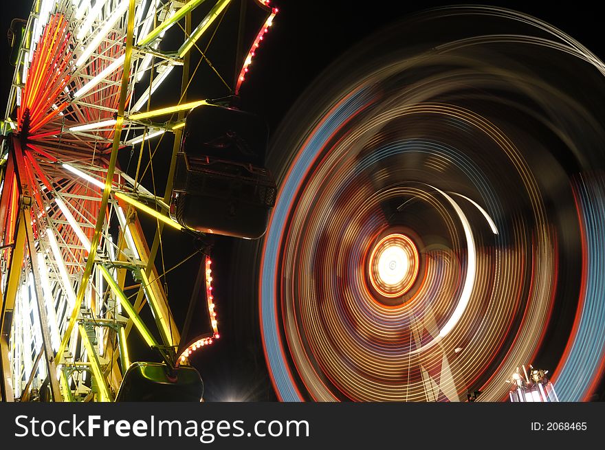 Ferris wheels at night motion blurred. Ferris wheels at night motion blurred