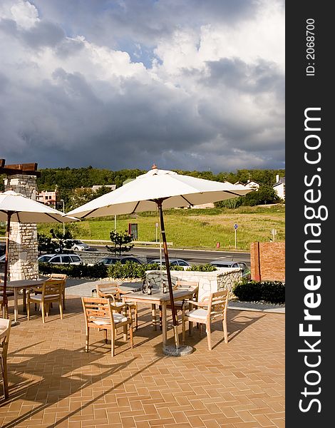 Mediterranean mood restaurant with white umbrellas, tables, sunshine