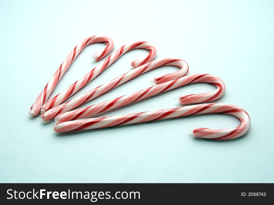Five candy canes on a white background