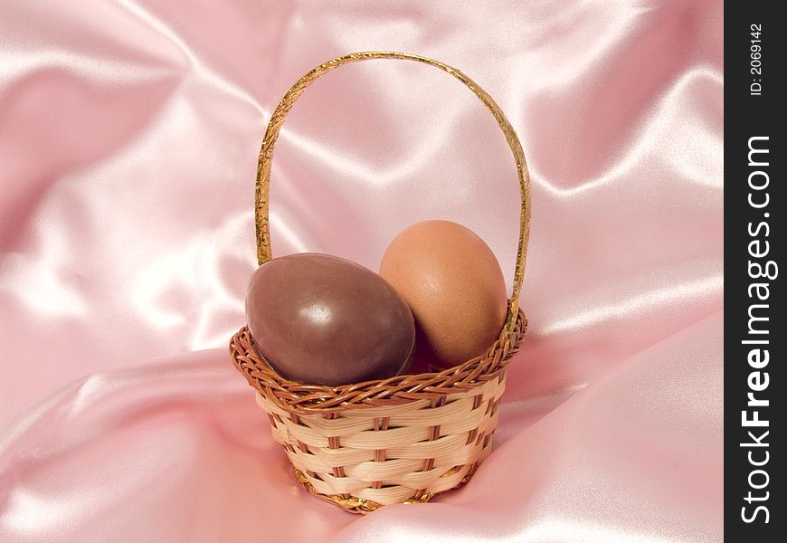 Eggs in a basket on a pink background to represent easter holidays. Eggs in a basket on a pink background to represent easter holidays