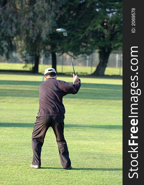 Golfer in mid swing with head of club in motion. Golfer in mid swing with head of club in motion