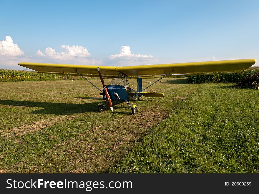 Small microlight aircarft parked in an airfield. Amateur built from plans 2-stroke engine, type Bagalini Colombo. Small microlight aircarft parked in an airfield. Amateur built from plans 2-stroke engine, type Bagalini Colombo