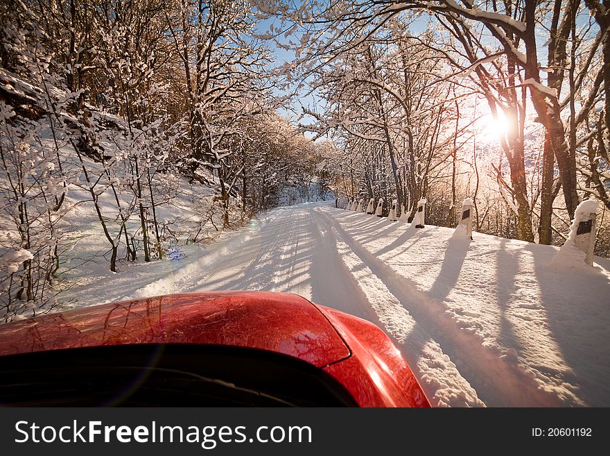 Snow-covered mountain road and red car. Snow-covered mountain road and red car