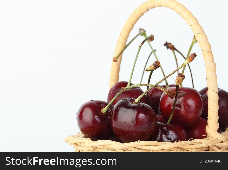 The cherry in bamboo basket on white background