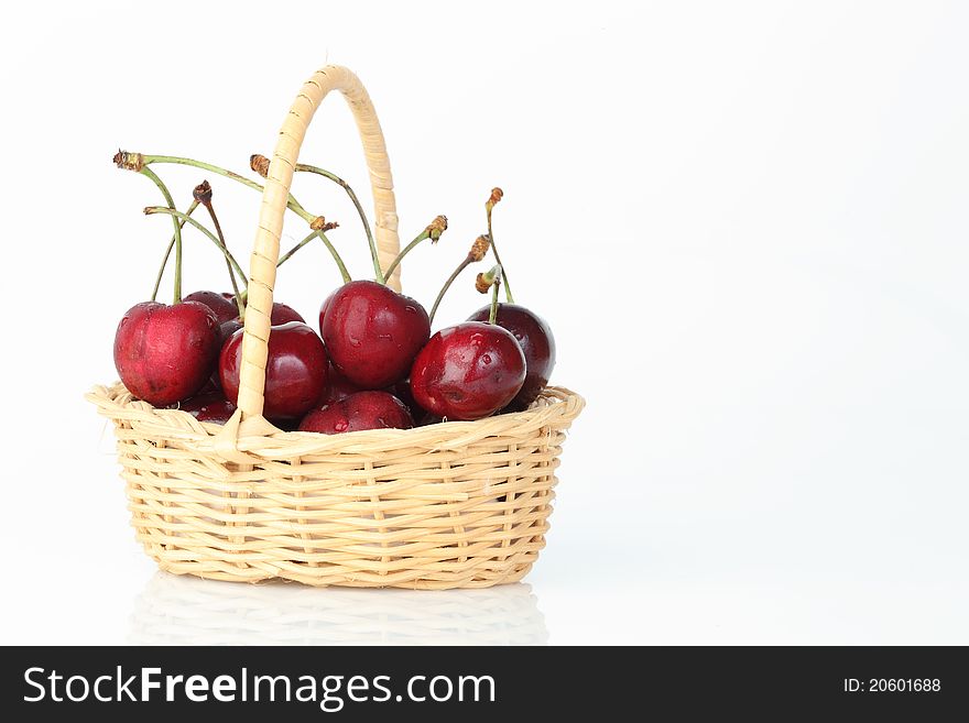 The cherry in bamboo basket on white background