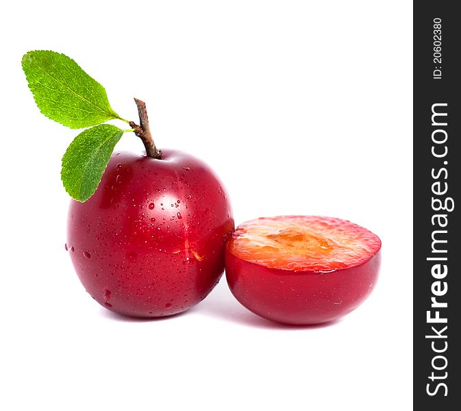 Fresh plum and a half with leafs isolated on white background