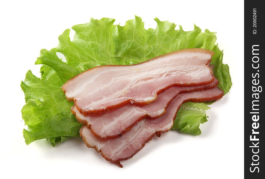 Some pieces of bacon on the green lettuce