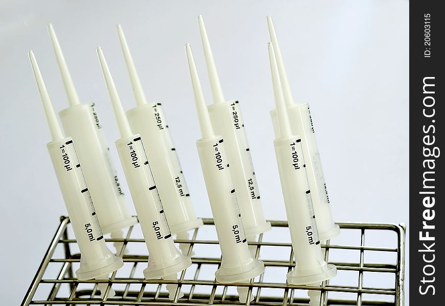 A row of syringe pipets on stand. A row of syringe pipets on stand