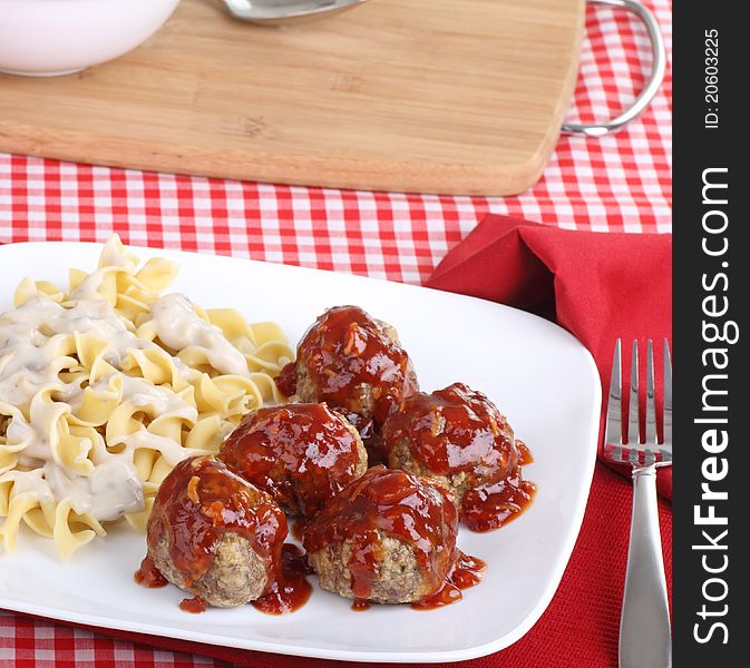 Meatballs covered with sauce and noodles on a plate. Meatballs covered with sauce and noodles on a plate