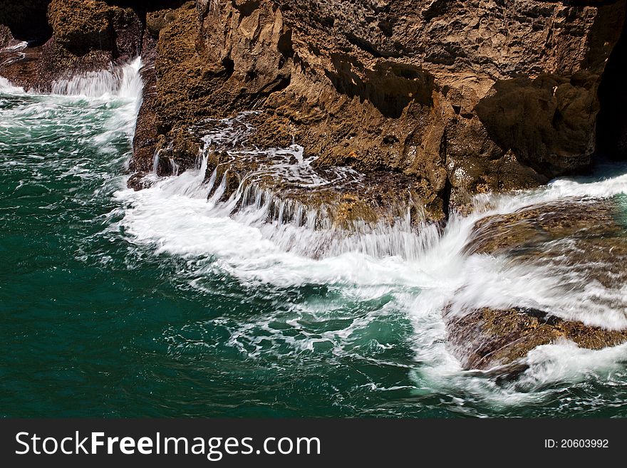 Intense ocean waves in chasm Boca do inferno located in the seaside cliffs close to the Portuguese city of Cascais. Tourists come here to see the waves crash into the rock. Intense ocean waves in chasm Boca do inferno located in the seaside cliffs close to the Portuguese city of Cascais. Tourists come here to see the waves crash into the rock.