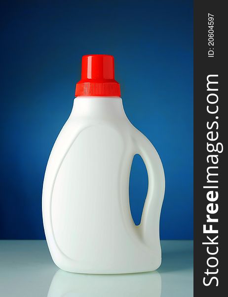 Liquid detergent in a bottle with a blue background. Liquid detergent in a bottle with a blue background
