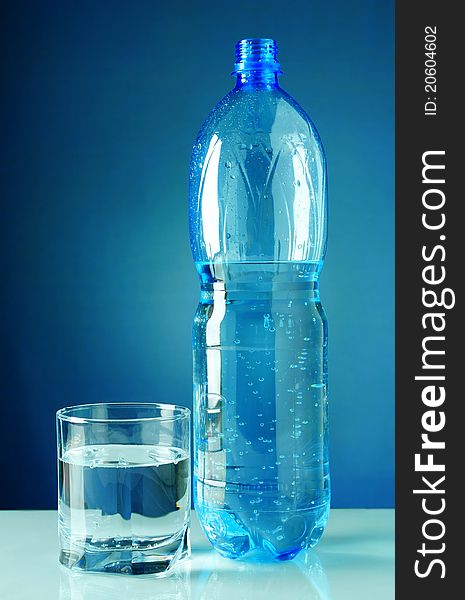 Water in plastic bottle with a blue background. Water in plastic bottle with a blue background