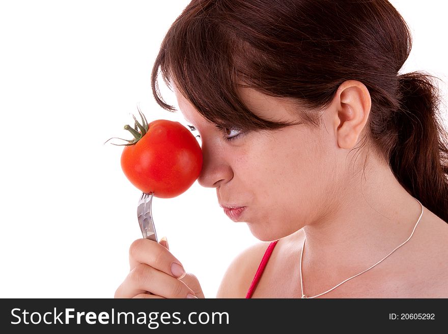 The pretty young woman has impaled a tomato. The pretty young woman has impaled a tomato