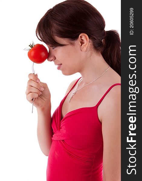 The pretty young woman has impaled a tomato. The pretty young woman has impaled a tomato