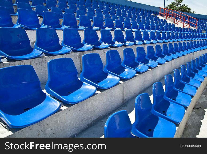 The rows of blue plastic chairs in football stadium. The rows of blue plastic chairs in football stadium