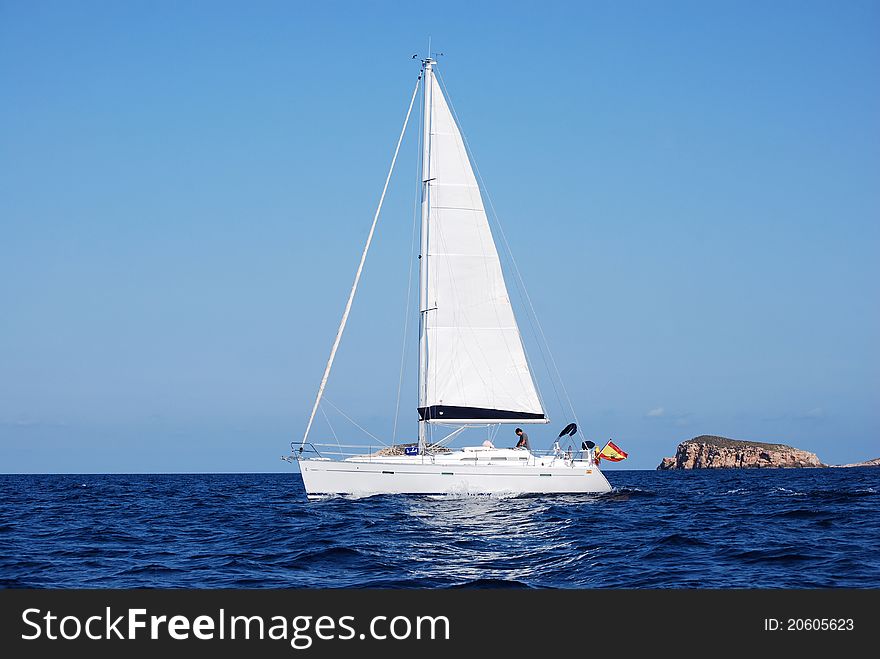 White sailing yacht in the Mediterranean. In the marine reserve of the little islands of Ibiza. White sailing yacht in the Mediterranean. In the marine reserve of the little islands of Ibiza.