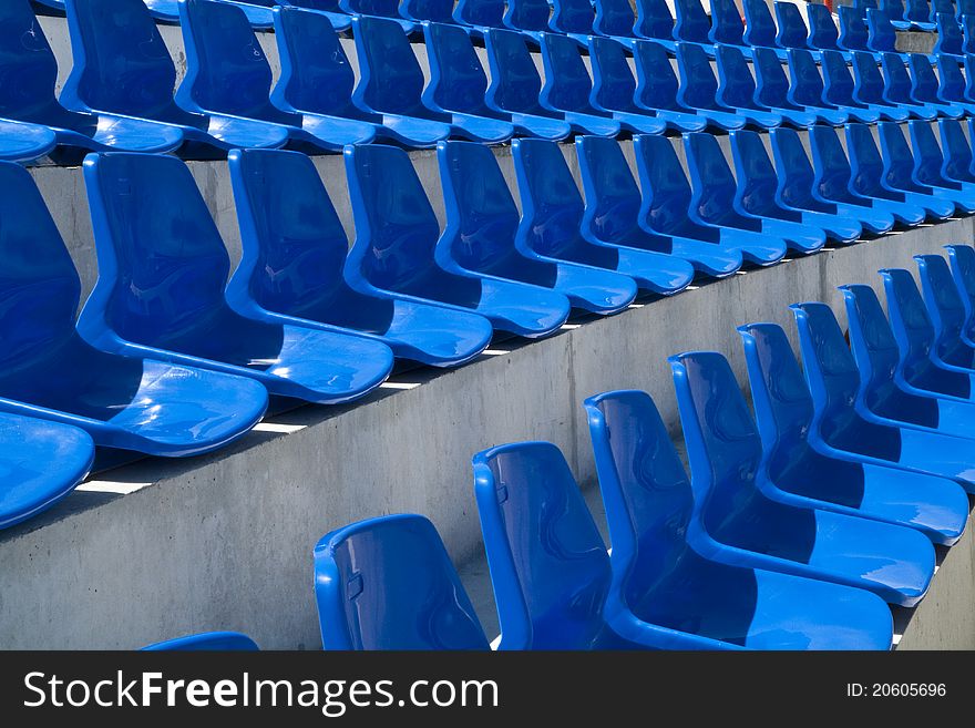 The rows of blue plastic chairs in football stadium. The rows of blue plastic chairs in football stadium