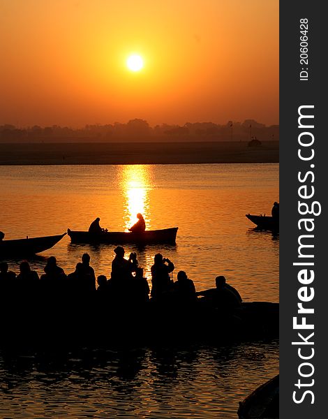 Varanasi sunrise with silhouetted tourists on local tourist boats taking photos. Varanasi sunrise with silhouetted tourists on local tourist boats taking photos