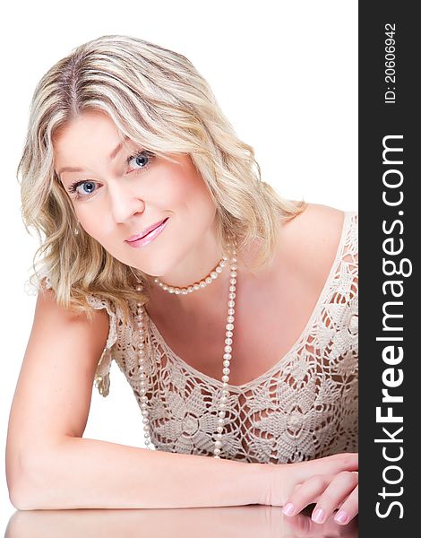 Portrait of coquettish beautiful young blonde woman wearing knitted lacy dress with pearl beads and bracelet on isolated white background. Portrait of coquettish beautiful young blonde woman wearing knitted lacy dress with pearl beads and bracelet on isolated white background