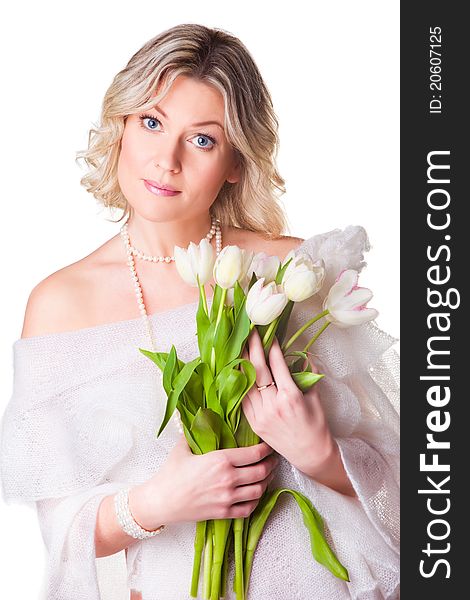 Beautiful young blonde woman with blue eyes holding bouquet of spring tulips wearing cozy woolen shawl on isolated white background. Beautiful young blonde woman with blue eyes holding bouquet of spring tulips wearing cozy woolen shawl on isolated white background