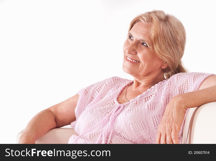Nice aged woman sitting on sofa on a white