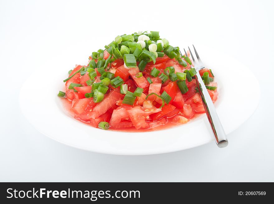 Tomato salad with spring onion on the white background