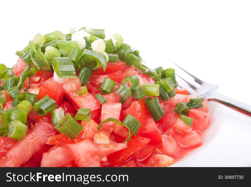 Tomato salad with spring onion on the white background