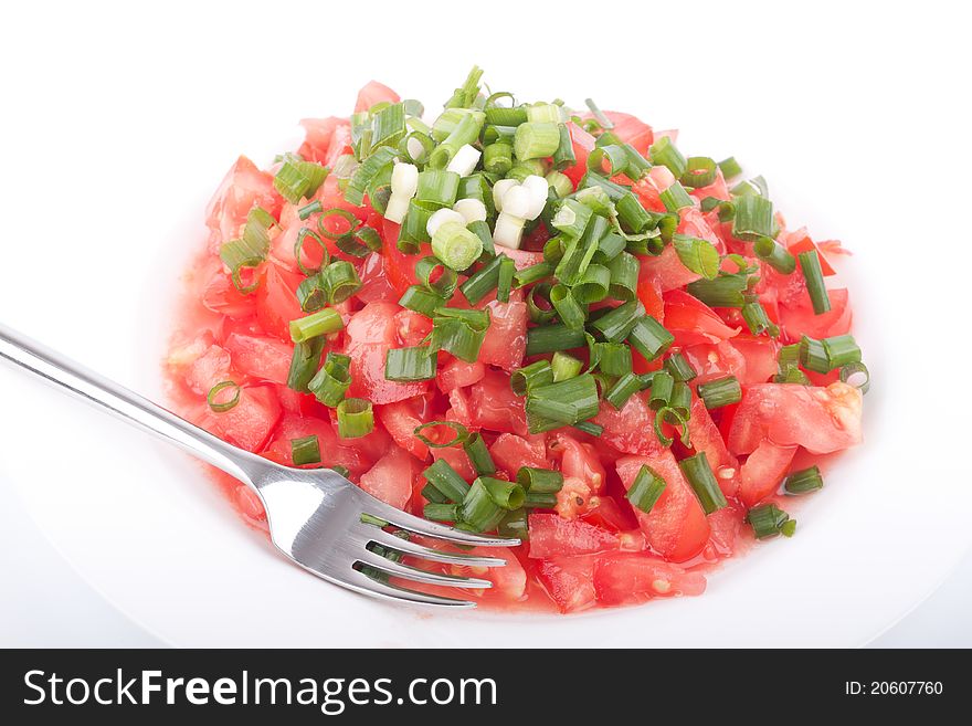 Tomato salad with spring onion on the white background