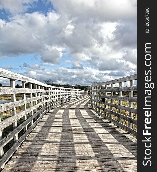 Wooden bridge with a cloudy sky. Wooden bridge with a cloudy sky