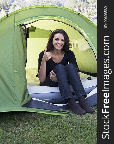Woman sitting in a green tent. Woman sitting in a green tent