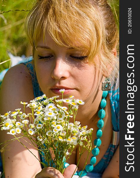 Blonde girl in grass with camomile flowers. Blonde girl in grass with camomile flowers