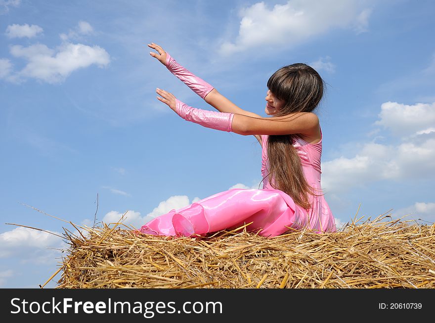A girl in a field stretching to the sky