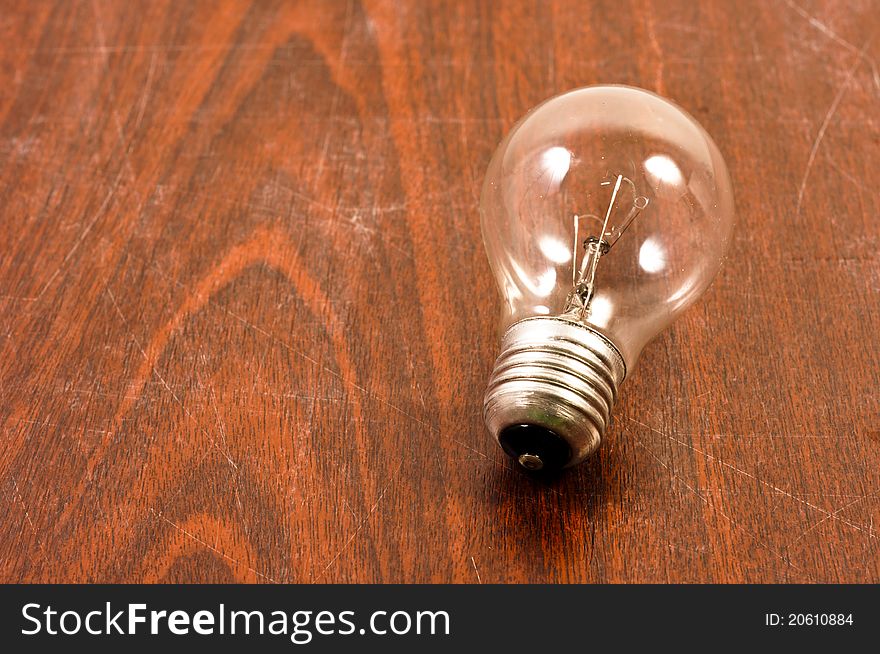 Light bulb on wooden plate in color