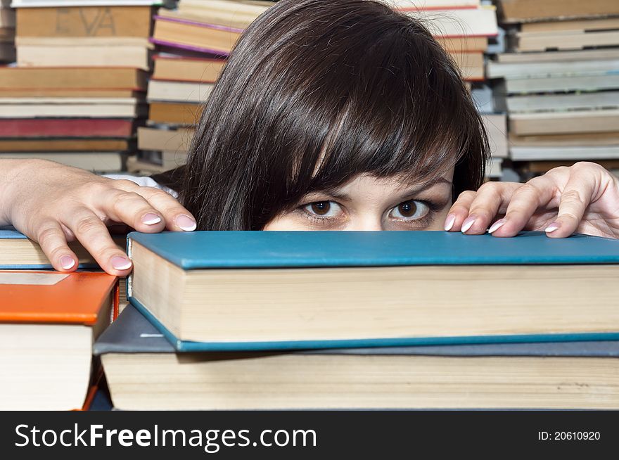 Young beautiful student girl behind books