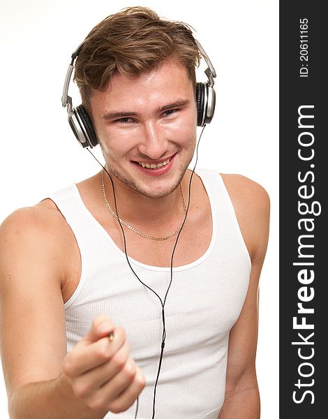 Man listening to the music in headphones on white background with smile on his face. Man listening to the music in headphones on white background with smile on his face