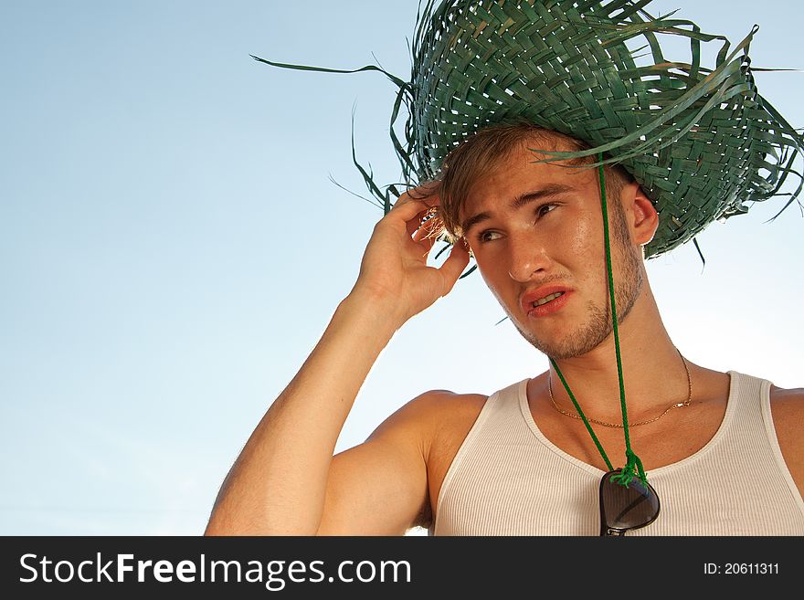 Tourist in straw hat on a blue sky background