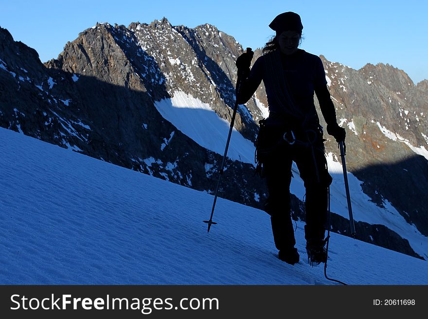 Silhouette of a climber walking across mountain glacier. Silhouette of a climber walking across mountain glacier