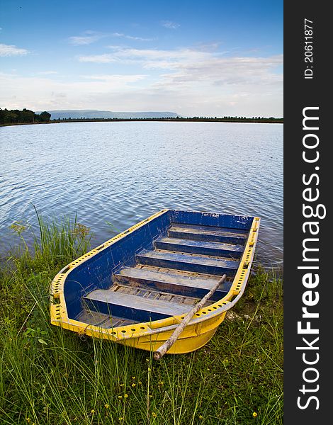 Yellow boat on the bank of the lake