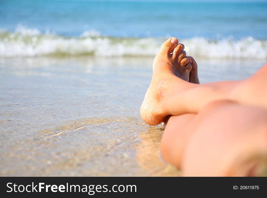 Wet female feet on the beach and sand. Wet female feet on the beach and sand