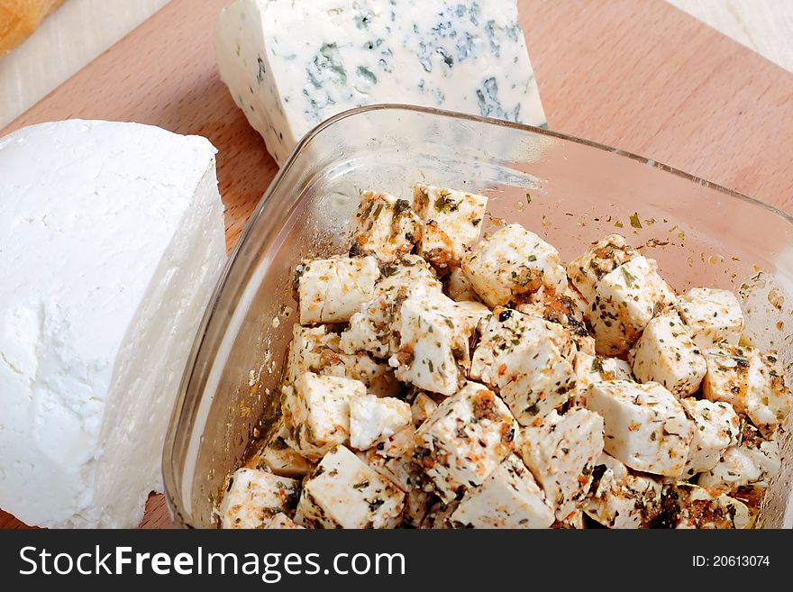 Various kinds of cheese on a wooden blackboard close up. Various kinds of cheese on a wooden blackboard close up