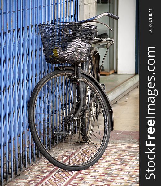 An old bicycle leaning against a shop front. An old bicycle leaning against a shop front